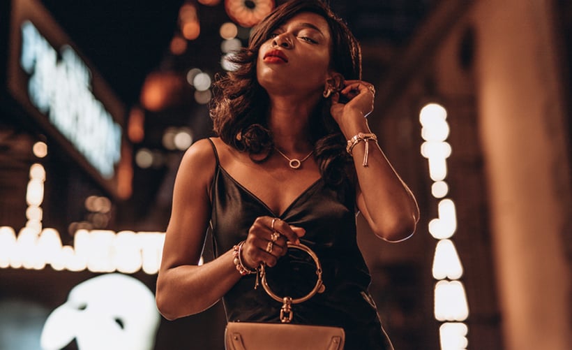 Content creator in silk black outfit and gold accessories at a musical theater show